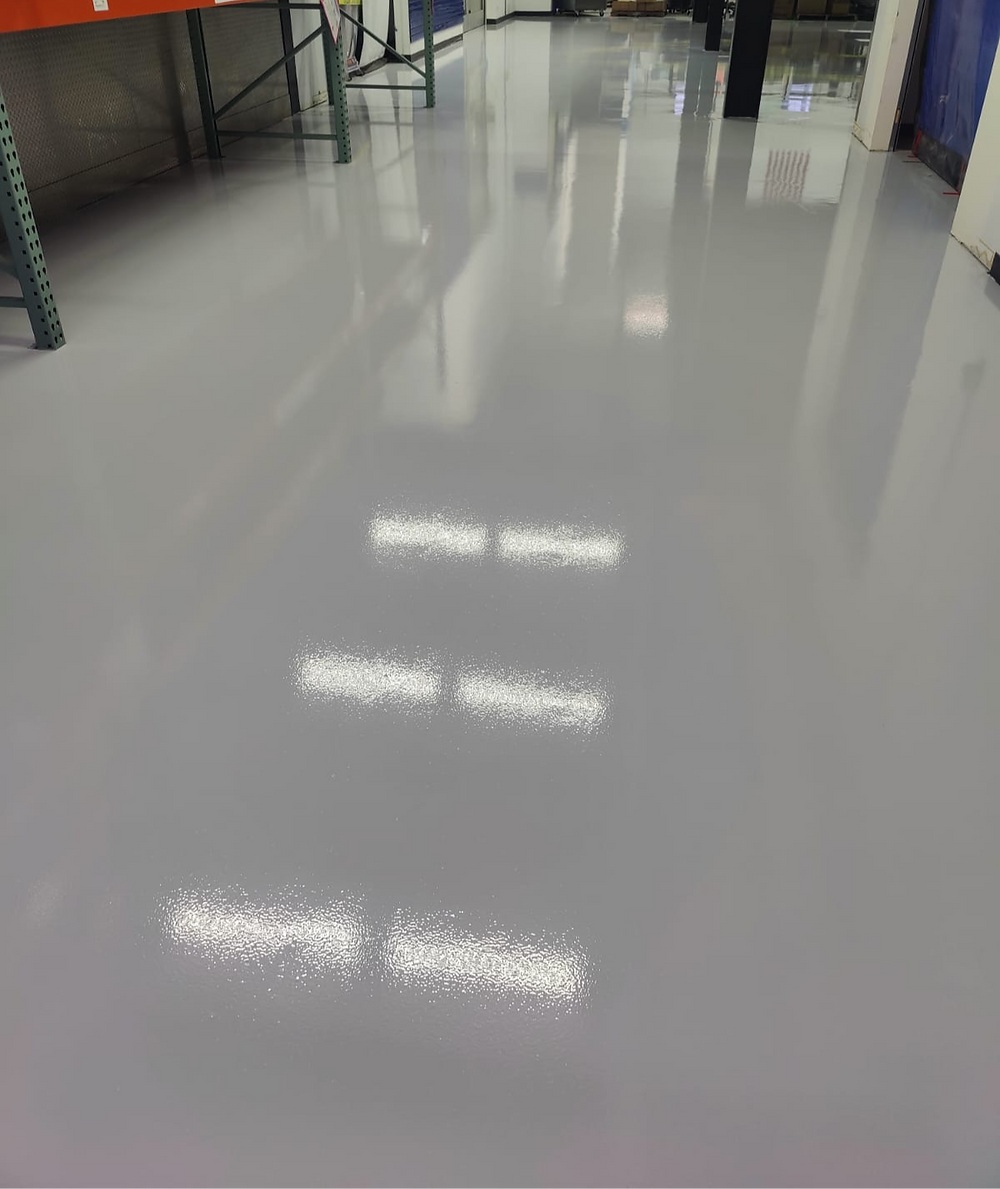 Polished gray floor reflecting ceiling lights