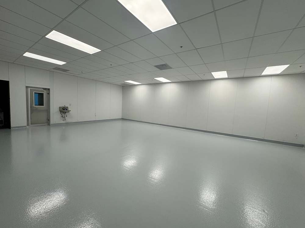 Empty cleanroom with reflective gray floor and white walls