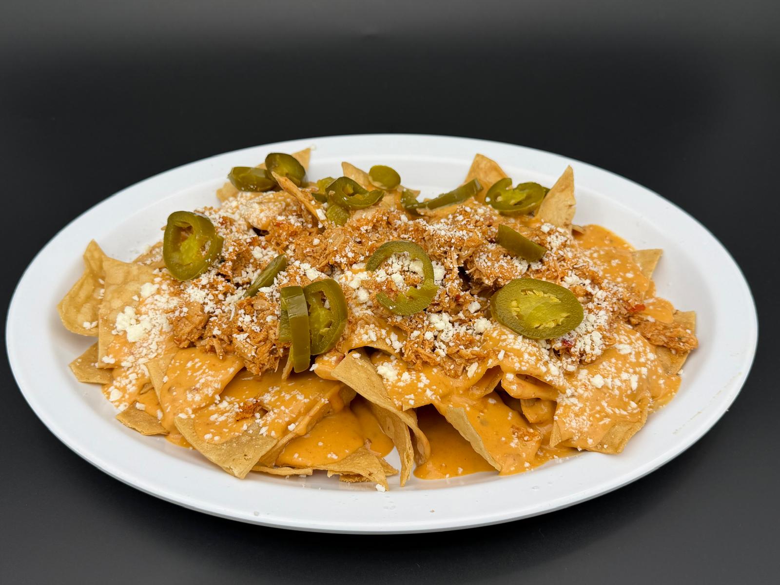 Pierna Nachos with marinated pork, beans, cheese and jalapeños