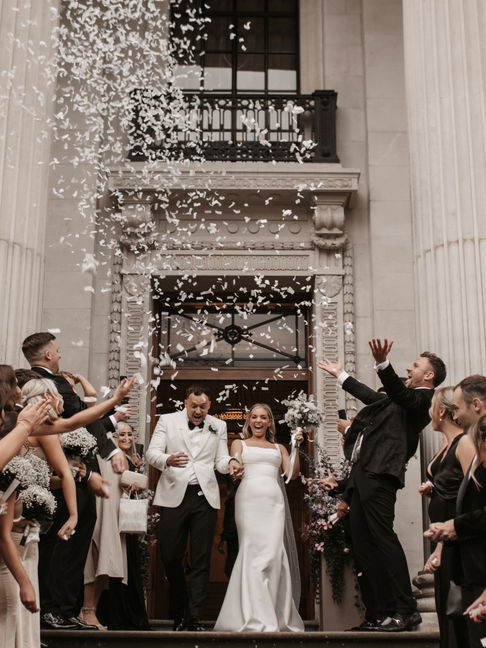 Confetti moment with bridal party celebrating outside Marylebone Town Hall.