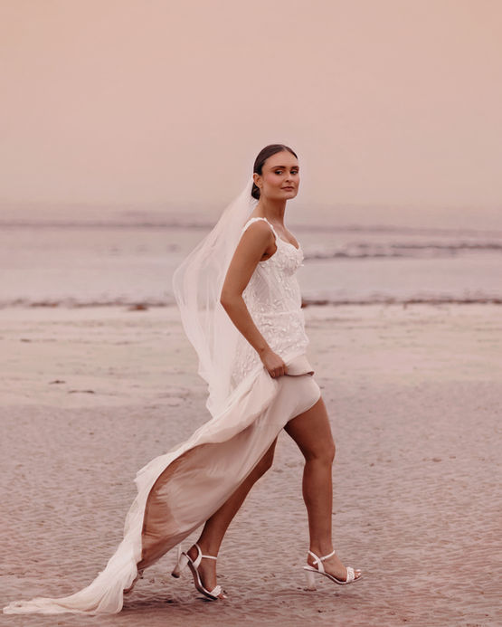 Bride on a Scottish beach during a real wedding, captured in a fashion-forward, elegant, and romantic style