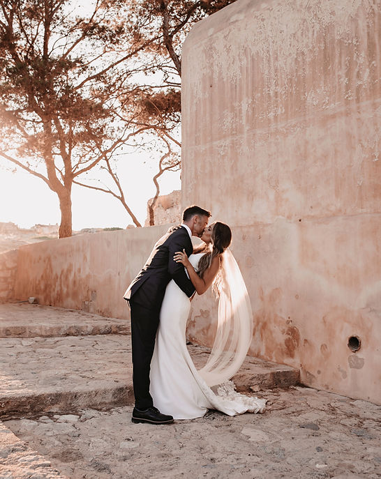 Couple sharing a romantic kiss at golden hour at Arodamos Villa, Greece, captured in an elegant, cinematic, and timeless wedding style