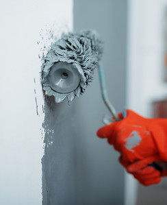 peintre qui peint un mur en gris