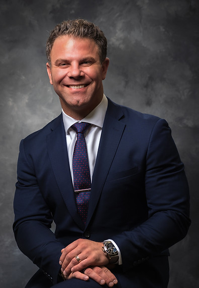 Craig Andriulli, professional headshot portrait, smiling in a suit.