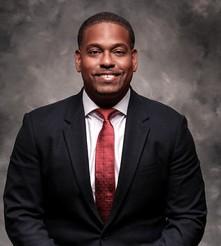 Carlos Duncanson in suit and tie poses for a professional portrait Fortress Mortgage Advisors.