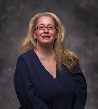 Woman with glasses smiles; blonde hair, blue shirt. Fortress Mortgage Ad.