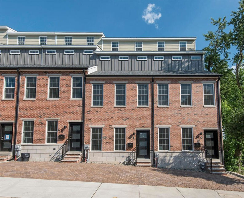 Multi-story multifamily apartment building with modern exterior and shared outdoor space.