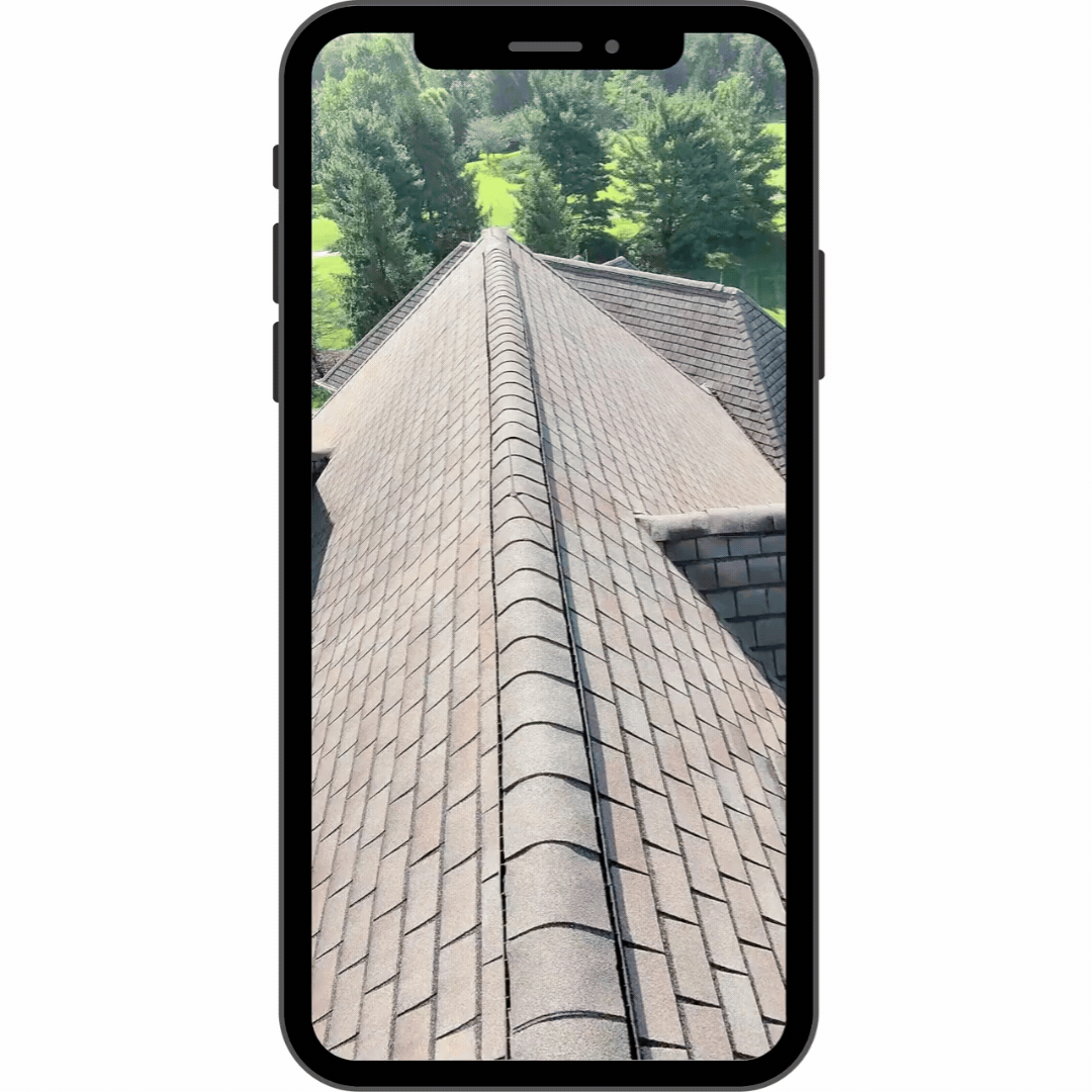 Smartphone screen showing a video recording of a roof slope and ridge caps during a RoofCo inspection.