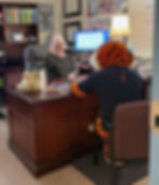 Picture of Mandi Buckelew at her desk with Aubie the Tiger from Auburn University