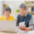 老夫婦がパソコンに向かって笑っている