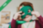 A boy holding a green mask
