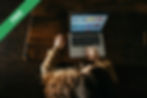 A person using a laptop on a wooden floor