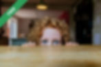 A young girl peeking over a table