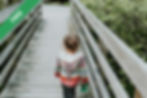 A girl standing on a wooden bridge