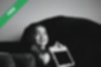 A young boy smiling while holding a tablet