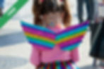 A young girl in rainbow wings and a skirt