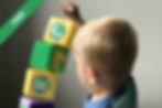A boy playing with blocks on a white table