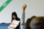 A student raising a hand in class