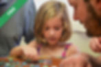 A girl playing at a wooden table