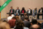 A group of people on a stage in front of a crowd