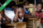 A boy sitting on a wooden desk chair