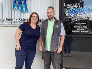 Owners of Plain Insane Graphix in front of building in Lemoore