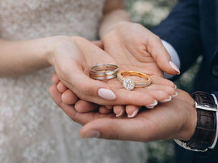 Alliances et bague de fiançailles dans les mains d’un couple symbolisant un PACS l l Salon du Diamant et de l’Alliance
