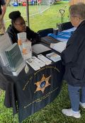 Elder Abuse Taskforce member speaking to a senior community member at the Genesee County Fair