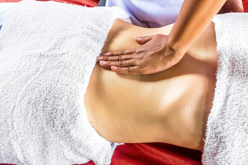 Hands giving a back massage on a person covered with a white towel. Red background. Relaxing and calming atmosphere.