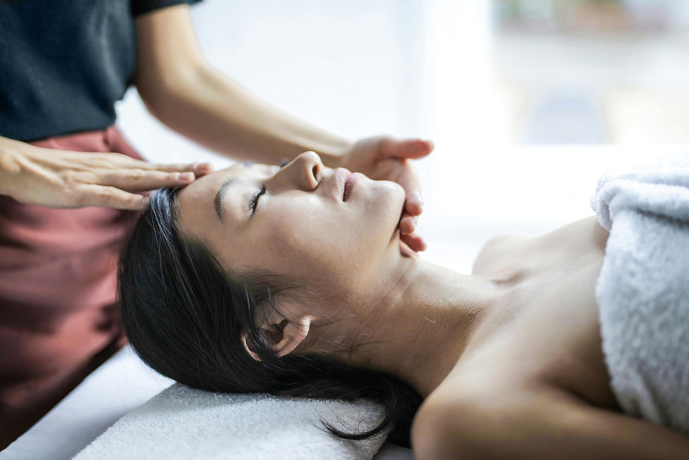 마사지 침대에 누운 여성이 편안한 표정으로 마사지를 받고 있다. 주변은 밝고 차분한 분위기이며 흰색 타월이 보인다.