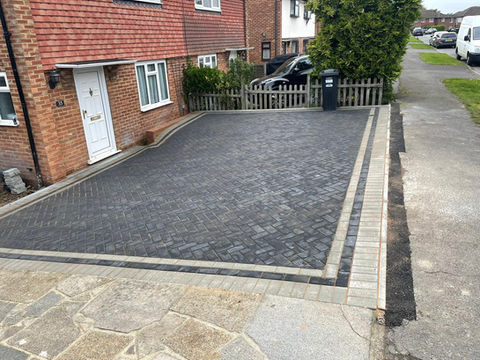 Square clay paving driveway with darker pavers around the edging 