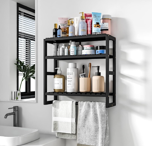 Black wall shelf with toiletries and towels in a bright bathroom beside a mirror, sink, and plant.
