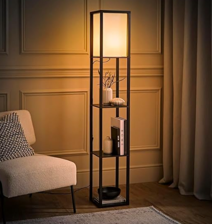 Floor lamp with warm light beside a beige chair in a cozy room. Shelves hold decor and books. Paneled wall and curtains in the background.