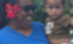 Smiling woman holding baby, waving