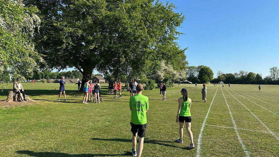 parkrunners under trees next to a running track painted on the grass playing fields