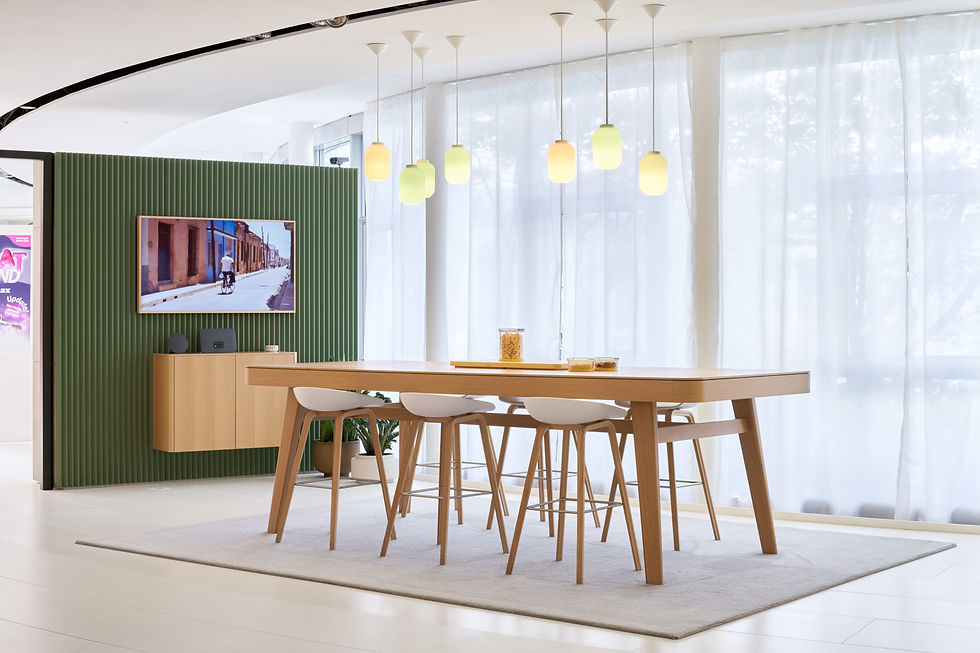 Moderner Essbereich mit Holztisch, Designerstühlen, hängenden Leuchten und grüner Akzentwand mit integriertem TV-Möbel.