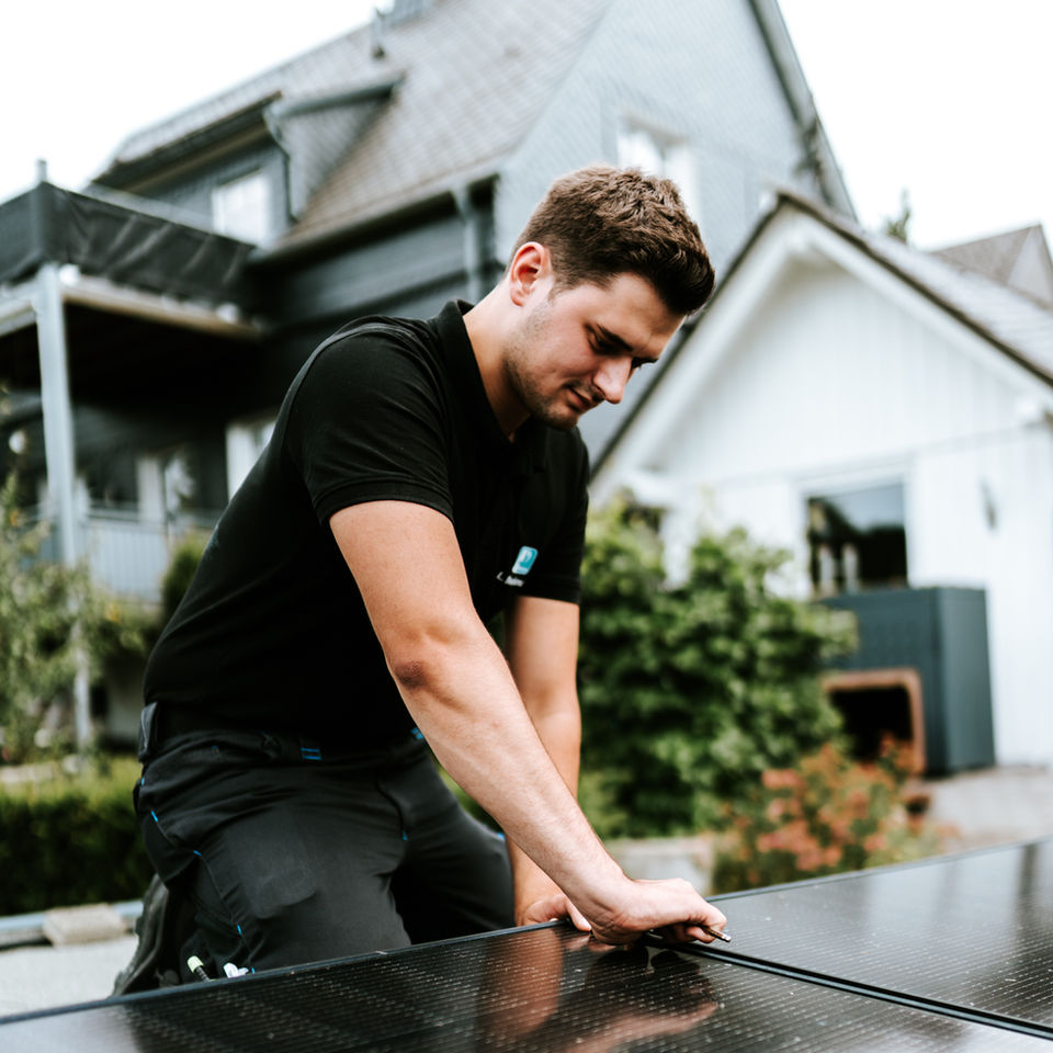 Junger Mitarbeiter während des Aufbaus einer PV-Anlage von Pletzinger Sauerland