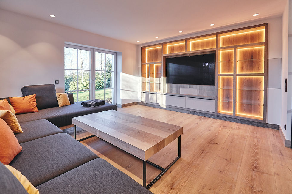 Modernes Wohnzimmer mit maßgefertigter TV-Wand und indirekter Beleuchtung, exklusiver Innenausbau von Biermann im Sauerland.