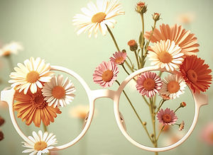 A pair of thin round oversized white eyeglasses adorned with a brightly colored daisies a