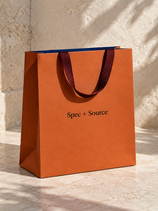Spec + Source orange shopping bag on stone surface