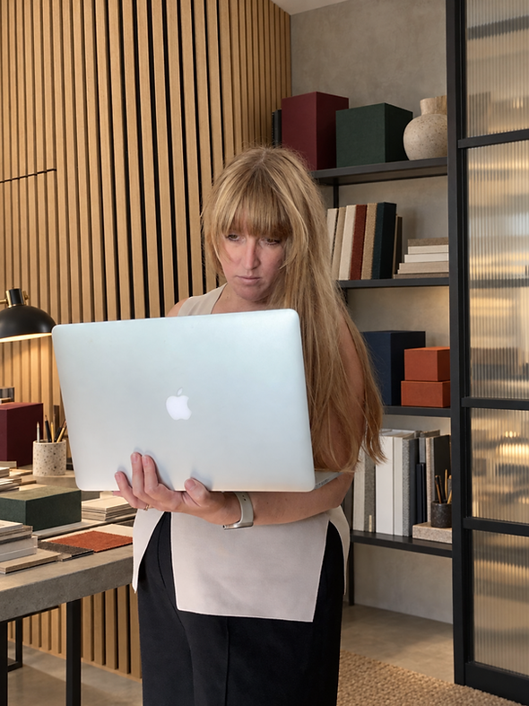 Woman using a laptop in a modern office setting.