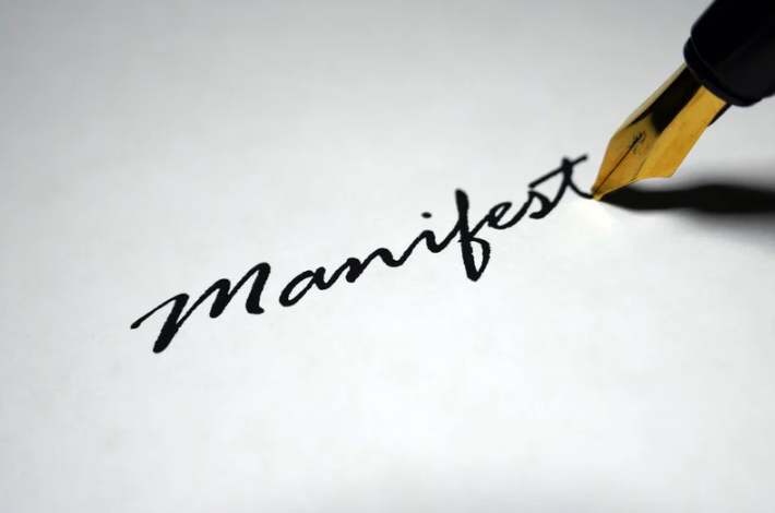 A pen writing the word "manifest"
