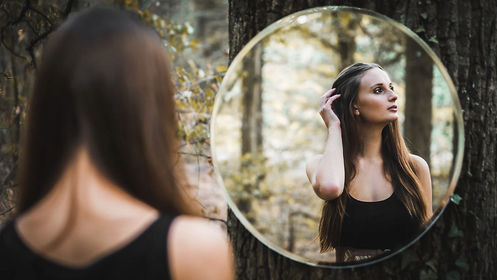 Woman looking in a mirror in the forest