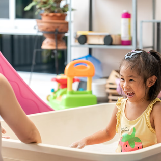 A mother and daughter enjoy playful bath time together at home.