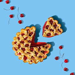 a pie with cherries around it