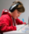 An ear training student having an online ear training lesson using headphones.