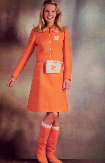 ancienne campagne publicitaire courrèges avec une mannequin blonde habillé en orange sur fond gris. 