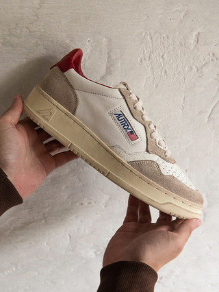 photo du modèle medialist low avec le détail arrière en bordeaux tenue dans des mains sur fond de crépis blanc