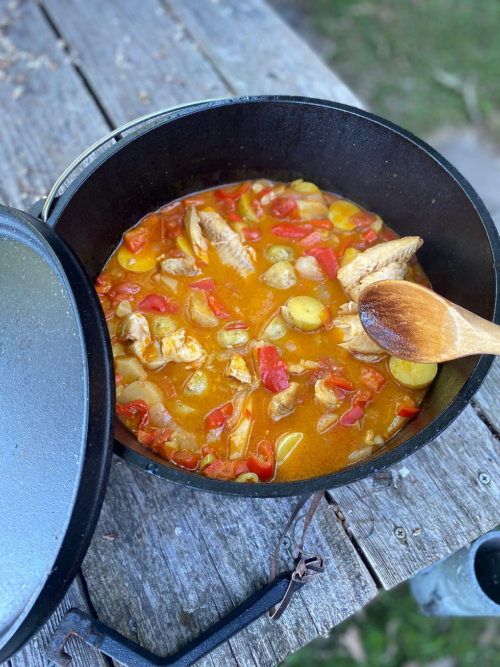 Hungarian fish stew in a pot with a wooden spoon