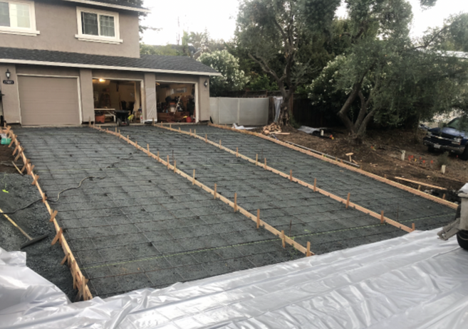 Workers installing concrete driveway.